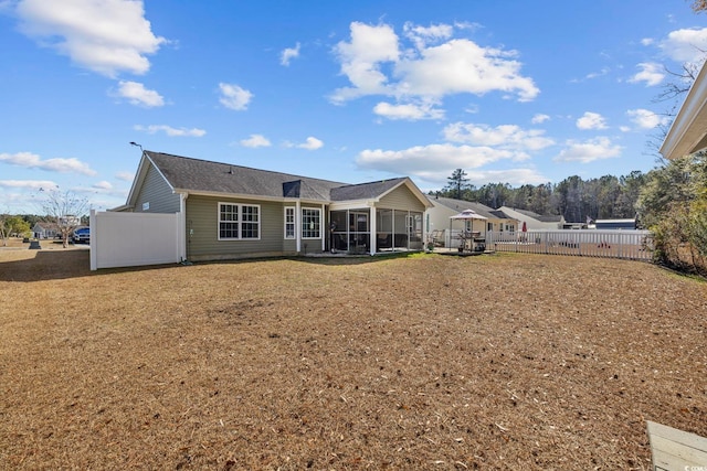 back of house with a lawn and a sunroom