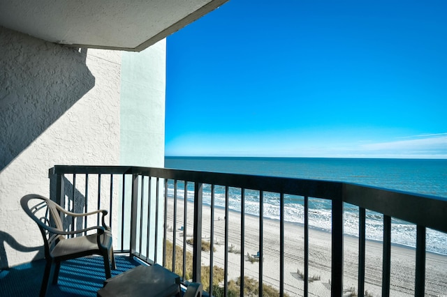 balcony featuring a view of the beach and a water view