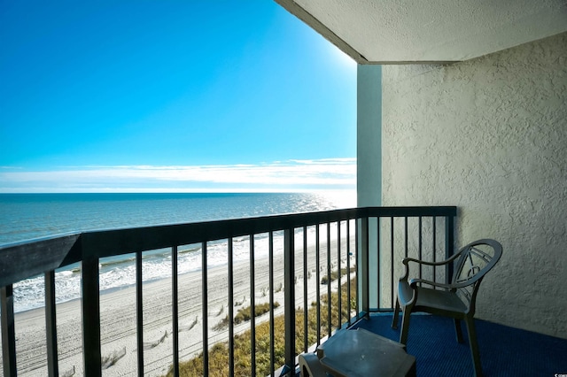 balcony with a water view and a beach view