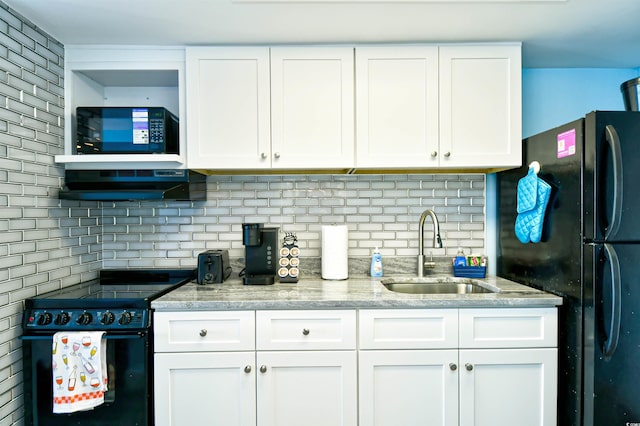 kitchen featuring range with electric cooktop, range hood, white cabinetry, sink, and black fridge