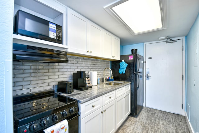 kitchen with white cabinetry, sink, black appliances, and dark stone countertops