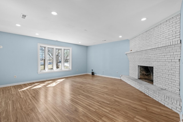 unfurnished living room featuring hardwood / wood-style flooring and a fireplace