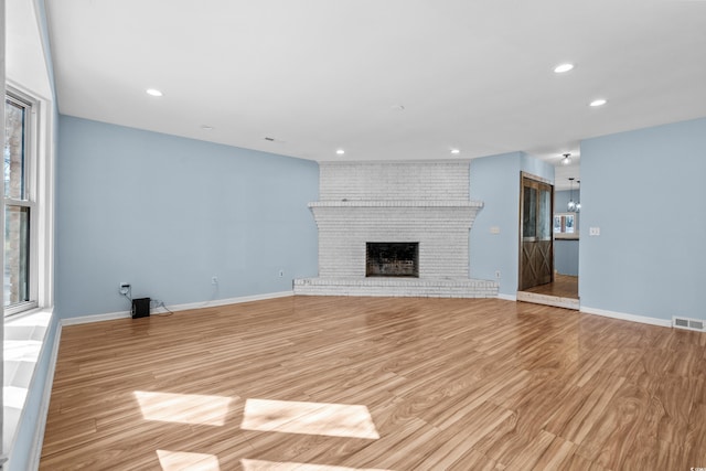 unfurnished living room featuring a fireplace and light hardwood / wood-style flooring