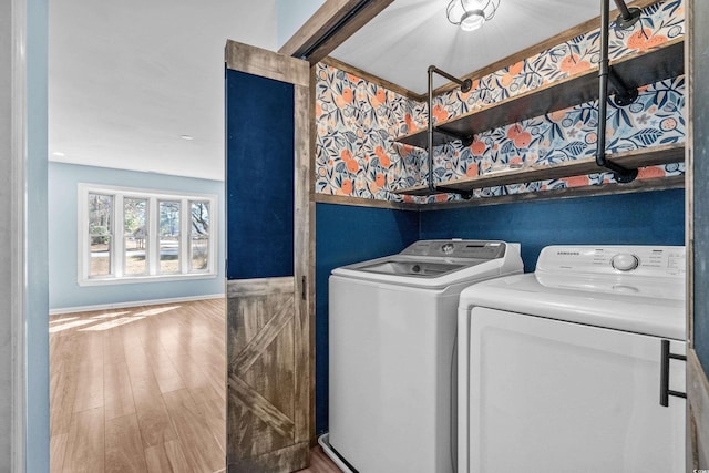 clothes washing area featuring washing machine and clothes dryer and wood-type flooring