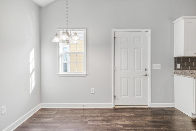 unfurnished dining area featuring dark hardwood / wood-style flooring and a chandelier