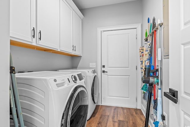 clothes washing area featuring cabinets, dark wood-type flooring, and washer and clothes dryer