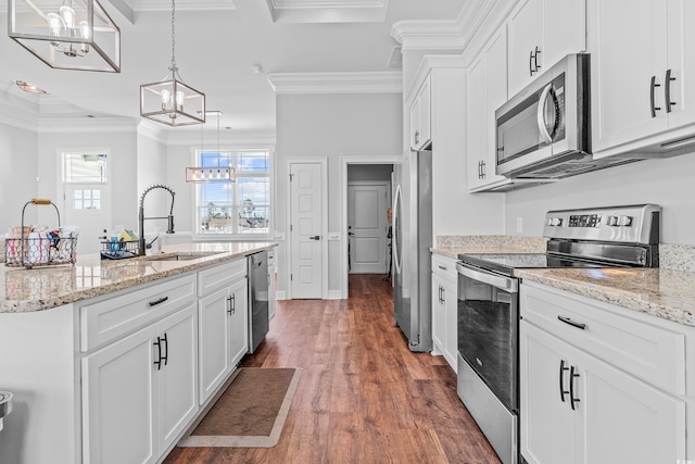 kitchen featuring white cabinetry, sink, hanging light fixtures, and appliances with stainless steel finishes