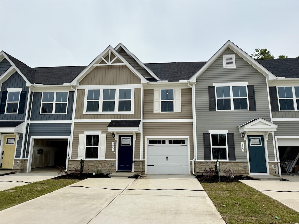 2065 NW Parow Ln NW Unit D, Calabash, NC 28467 - view of front of home featuring stone siding, driveway, board and batten siding, and roof with shingles