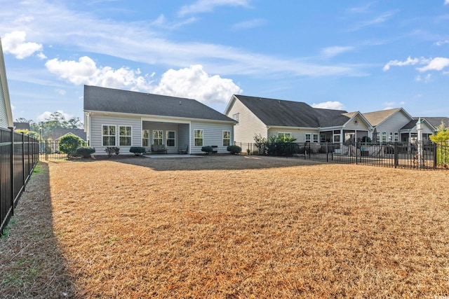 rear view of property featuring a patio area and a lawn