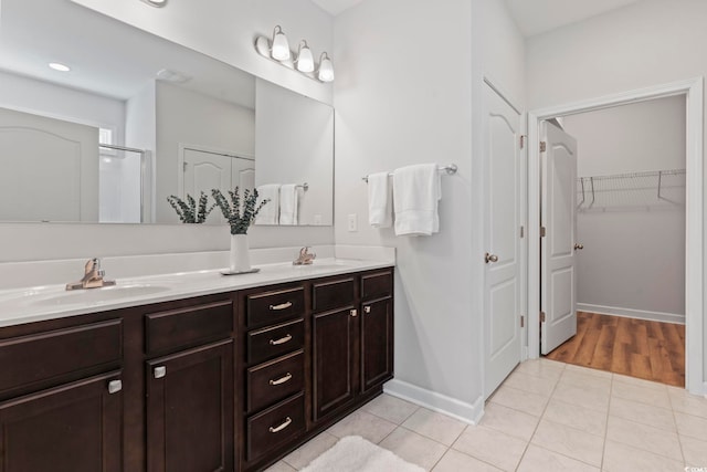 bathroom with tile patterned floors, an enclosed shower, and vanity