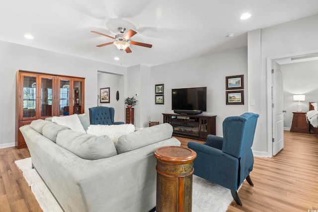 living room featuring ceiling fan and light hardwood / wood-style floors