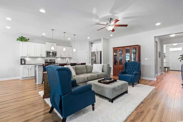 living room with ceiling fan and light wood-type flooring