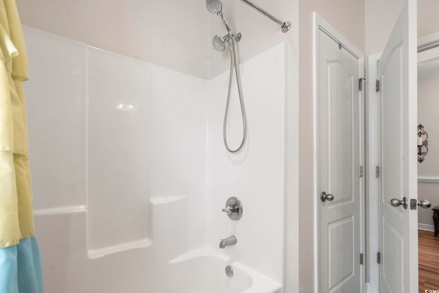 bathroom with bathtub / shower combination and hardwood / wood-style floors