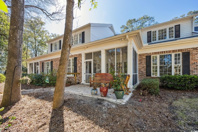 489-3 Golden Bear Dr Unit 3, Pawleys Island, SC 29585 - rear view of house with brick siding, a sunroom, and a patio