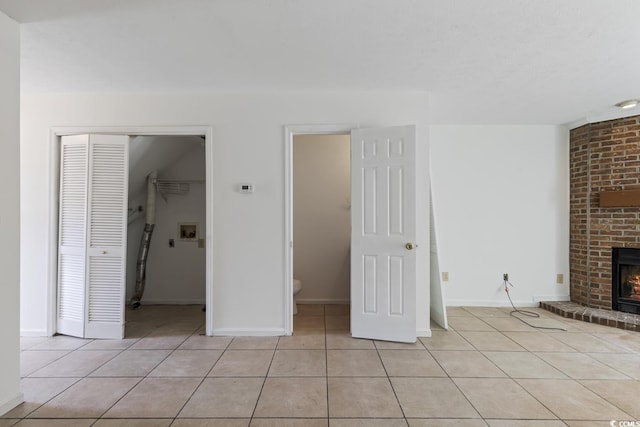 1025 Carolina Rd Unit I-7, Conway, SC 29526 - unfurnished living room with light tile patterned floors, a brick fireplace, and baseboards