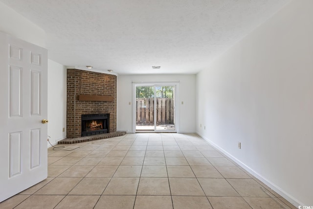 1025 Carolina Rd Unit I-7, Conway, SC 29526 - unfurnished living room featuring light tile patterned floors, a brick fireplace, a textured ceiling, and baseboards