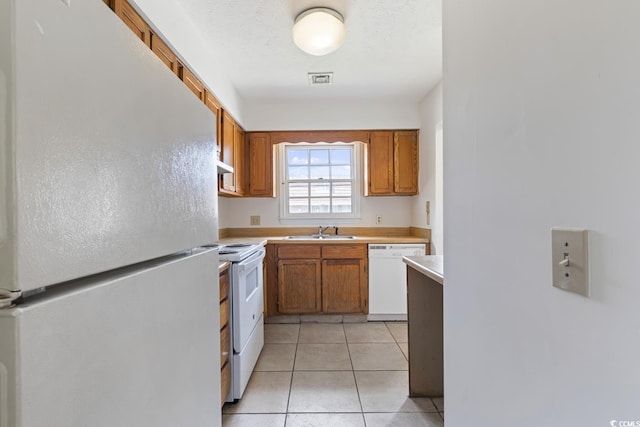 1025 Carolina Rd Unit I-7, Conway, SC 29526 - kitchen featuring white appliances, light countertops, a sink, brown cabinetry, and light tile patterned floors