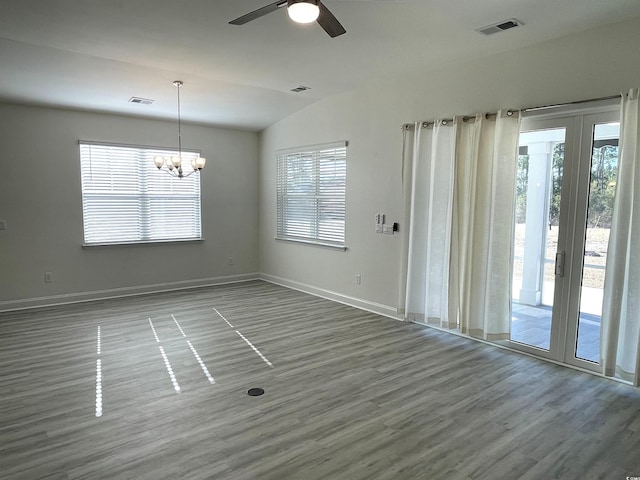 unfurnished room featuring hardwood / wood-style flooring, vaulted ceiling, and ceiling fan with notable chandelier