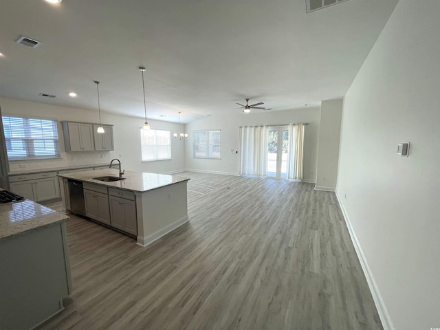 kitchen featuring sink, gray cabinetry, hanging light fixtures, dishwasher, and an island with sink