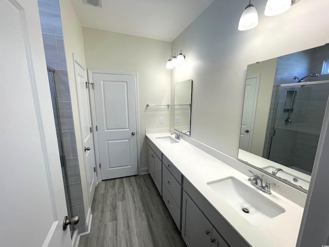 bathroom with vanity, hardwood / wood-style flooring, and walk in shower