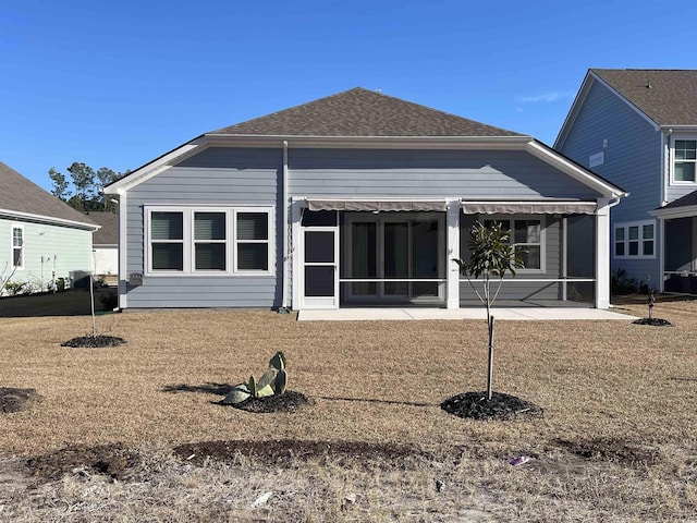 back of house featuring a yard and a sunroom