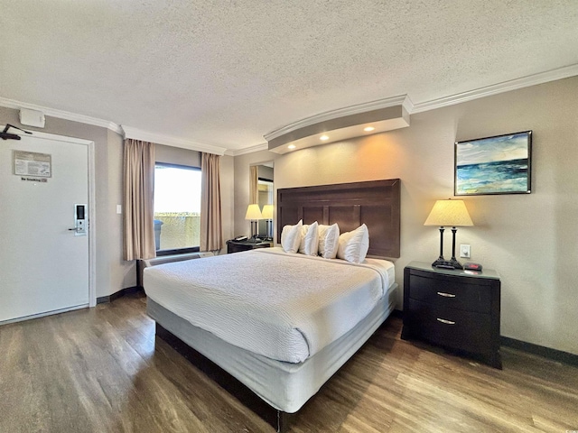 bedroom with ornamental molding, a textured ceiling, and wood finished floors