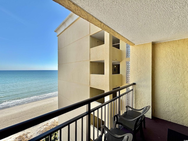 balcony featuring a water view and a view of the beach