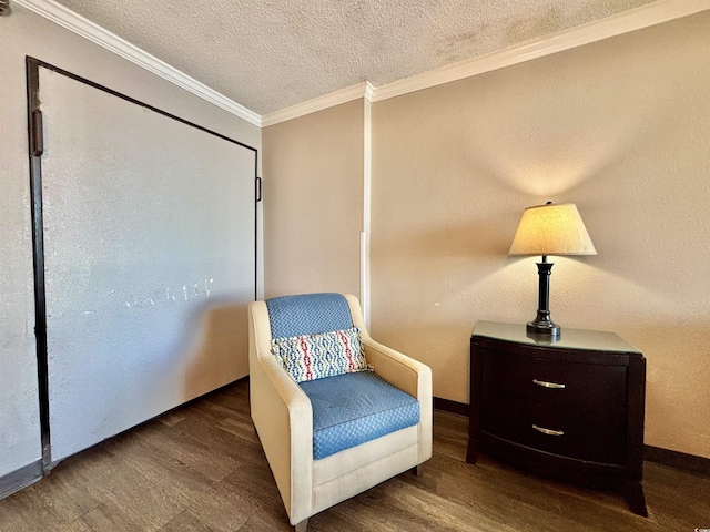 sitting room with ornamental molding, dark wood finished floors, a textured ceiling, and baseboards