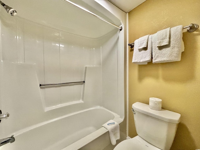 bathroom featuring bathtub / shower combination and toilet