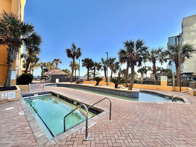 view of pool with fence and a community hot tub