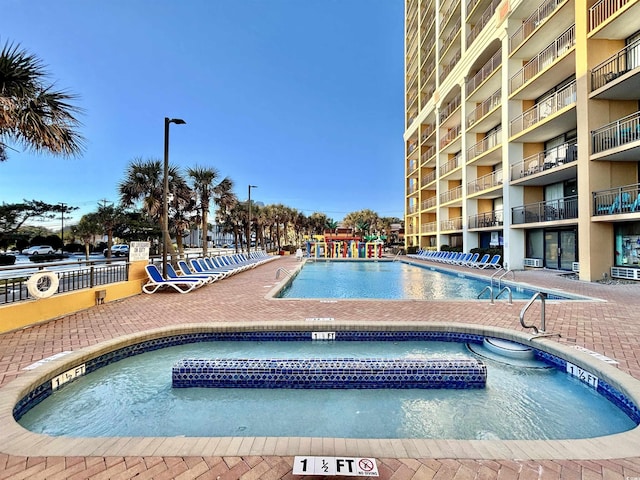 view of swimming pool featuring a hot tub