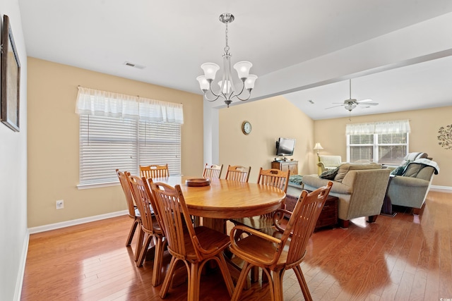 dining space featuring ceiling fan with notable chandelier and hardwood / wood-style floors