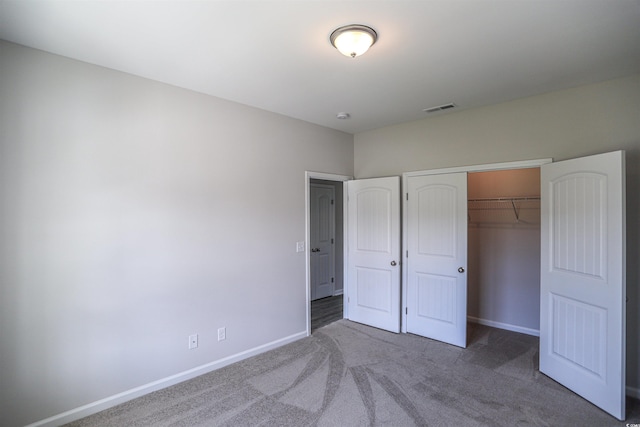 unfurnished bedroom with visible vents, carpet floors, baseboards, and a closet