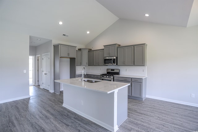 kitchen featuring a sink, light wood-style floors, appliances with stainless steel finishes, and gray cabinetry