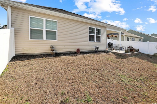 rear view of property featuring a lawn and a patio area