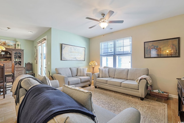 living room with ceiling fan and light hardwood / wood-style flooring