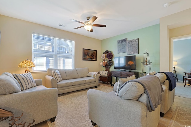 living room with ceiling fan and light hardwood / wood-style flooring