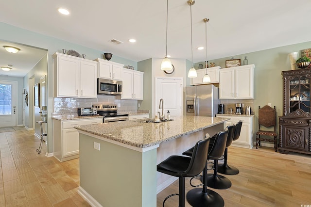 kitchen with white cabinetry, an island with sink, appliances with stainless steel finishes, and sink