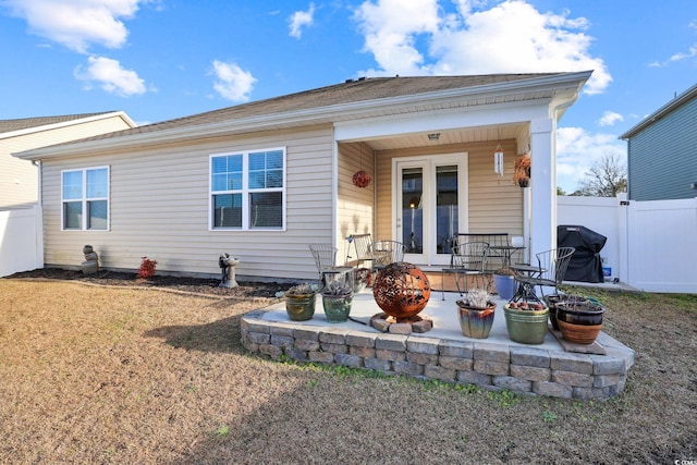 rear view of house with french doors, a patio, and an outdoor fire pit