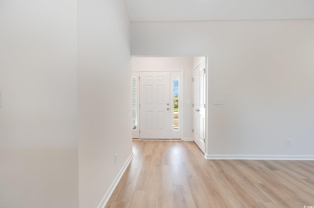 foyer entrance featuring light wood finished floors and baseboards