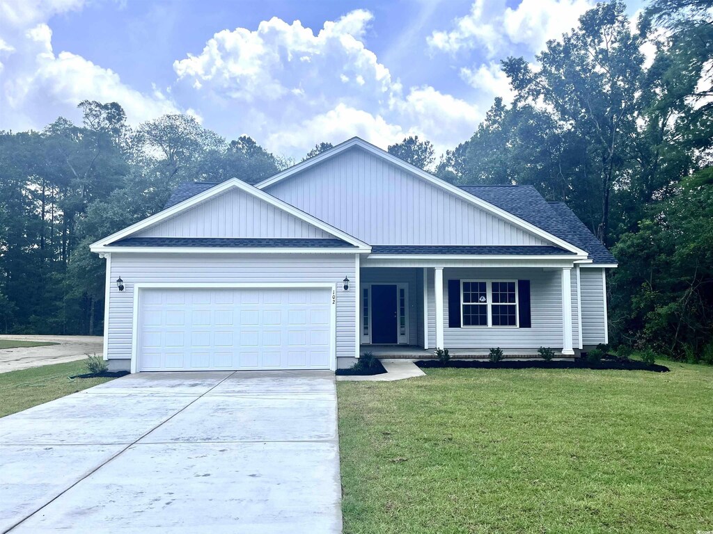 102 Telfair Rd, Georgetown, SC 29440 - ranch-style house with driveway, covered porch, a front yard, a shingled roof, and a garage
