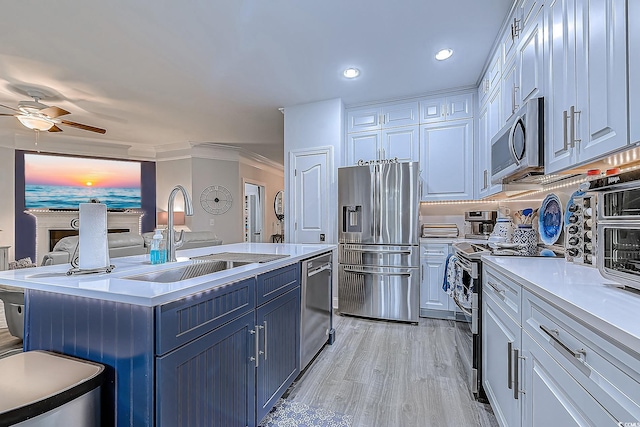 kitchen featuring sink, appliances with stainless steel finishes, white cabinetry, light hardwood / wood-style floors, and an island with sink