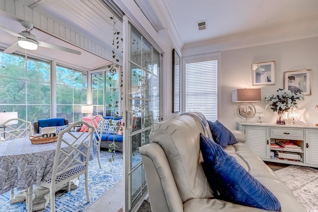 living room with hardwood / wood-style flooring, crown molding, and ceiling fan