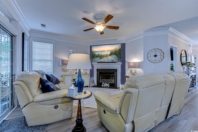 living room featuring crown molding, ceiling fan, and light hardwood / wood-style flooring