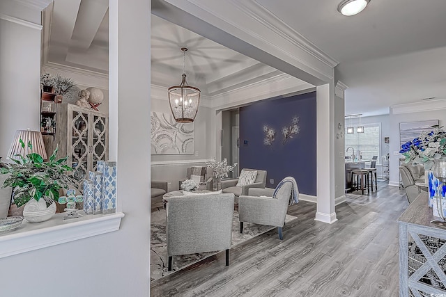 living room with hardwood / wood-style floors, crown molding, and a notable chandelier