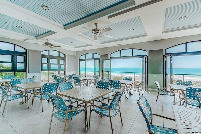 sunroom with coffered ceiling, a water view, a healthy amount of sunlight, and beam ceiling