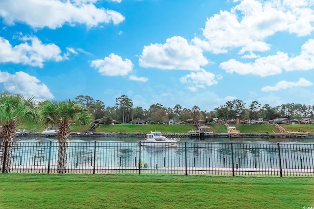 view of pool with a water view and a lawn