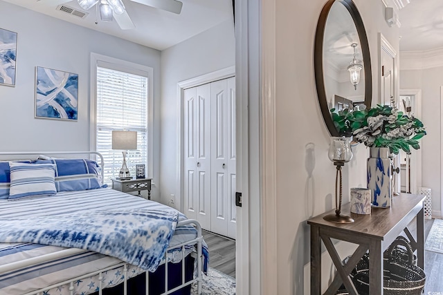 bedroom featuring wood-type flooring, ceiling fan, and a closet