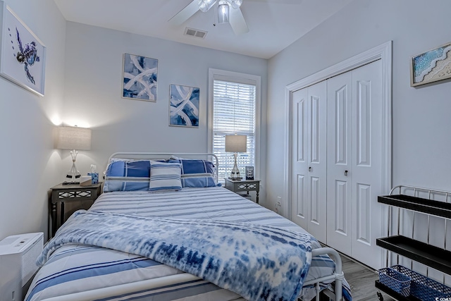 bedroom with ceiling fan, wood-type flooring, and a closet