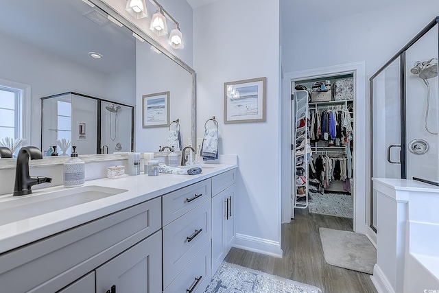 bathroom with hardwood / wood-style flooring, vanity, and a shower with door